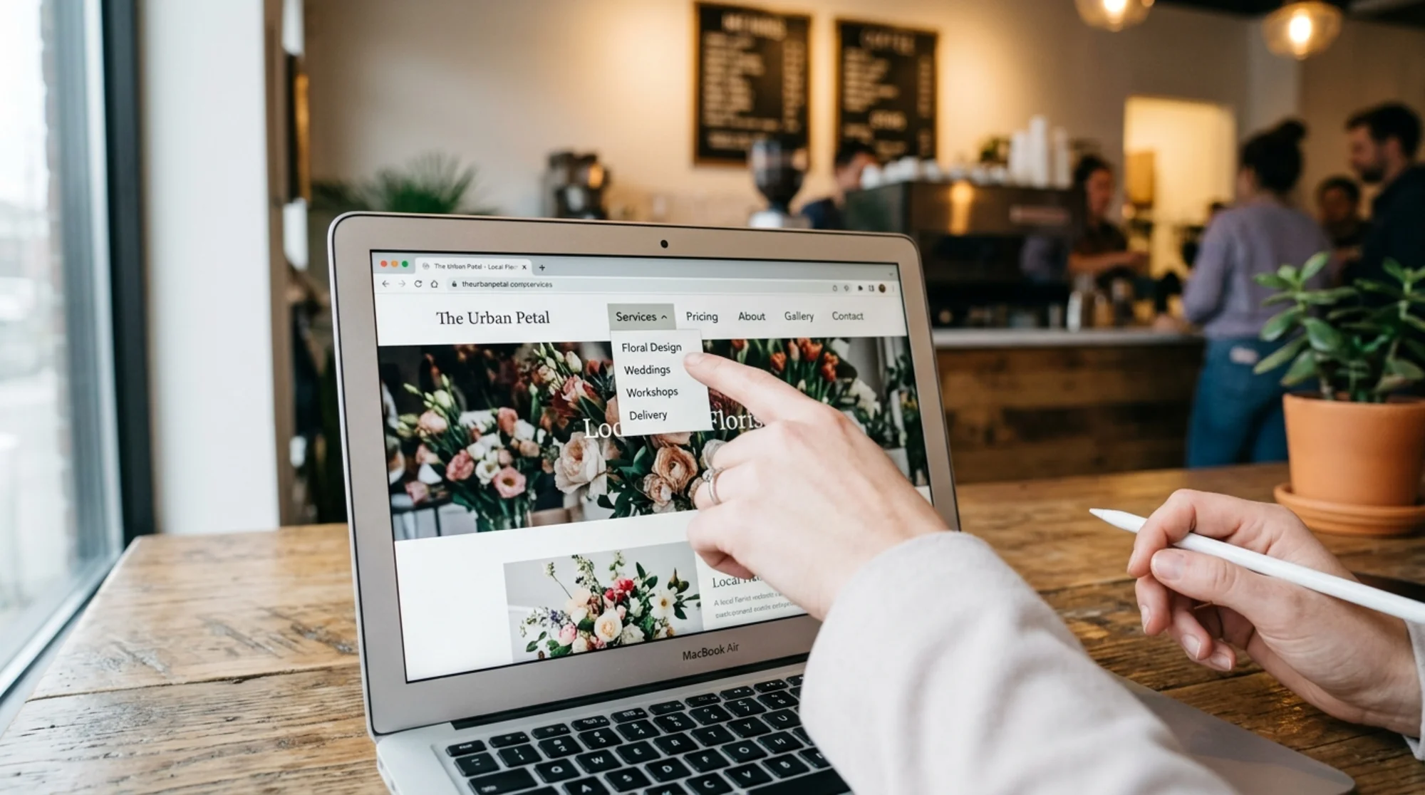 Close-up of a small business website header on a laptop showing a clean top navigation bar with labels Services, Pricing, About, Contact, with a customer's hand pointing at the Services dropdown